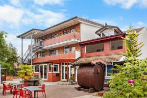 a building with tables and chairs in front of it at Gästehaus Parkblick in Rust