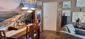 a dining room with a table and a painting on the wall at Windy Guesthause in Grundarfjordur