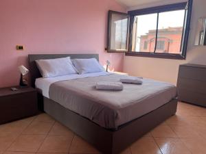 a bedroom with a large bed with two towels on it at Alma's house in Donigala Fenughedu