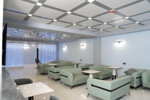 a waiting room with tables and green chairs at GRIG Villa & Hotel in Stepʼanavan