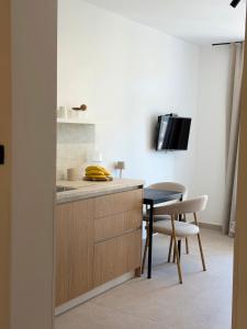 a kitchen with a counter and a table and a tv at Apartments M&E in Mokošica