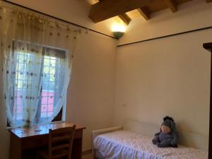 a teddy bear sitting on a bed in a bedroom at Appartamento Villa Reale in Castel SantʼAngelo