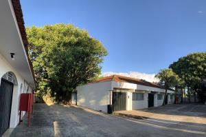 an empty street with trees and a building at Ipê Hotel Jardins in Ponta Grossa