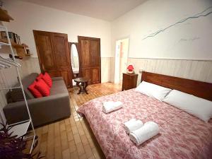 a bedroom with a bed and a couch with towels at Bellagio, Como Lake Breva - Como Lake in Bellagio