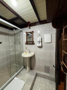 a bathroom with a sink and a glass shower at Chalé Coração de Monte Verde in Monte Verde +67 photos