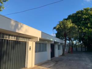 a building with a garage and a palm tree at Ipê Hotel Jardins in Ponta Grossa +55 photos