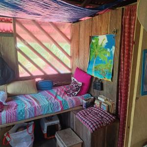 a small room with a bed and a window at TANGARA Hostel in Buenaventura