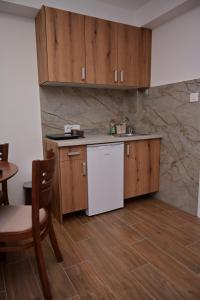 a kitchen with wooden cabinets and a white refrigerator at Apartments Gajić with Private Free Parking - New & Modern in Bar