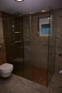 a bathroom with a shower with a toilet and a window at Apartments Gajić with Private Free Parking - New & Modern in Bar
