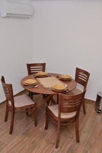 a wooden table with four chairs and a wooden floor at Apartments Gajić with Private Free Parking - New & Modern in Bar +15 photos