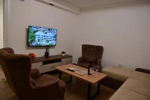 a living room with a couch and a table and a tv at Apartments Gajić with Private Free Parking - New & Modern in Bar