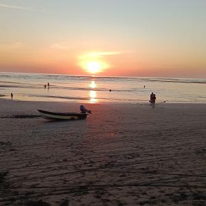 a boat sitting on the beach at sunset at TANGARA Hostel in Buenaventura +5 photos
