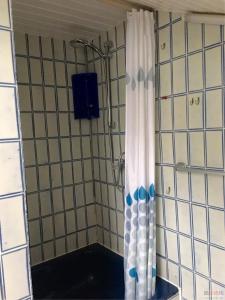 a shower in a bathroom with a shower curtain at Train Fans in Seevetal