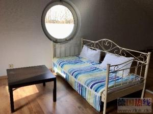 a bedroom with a bed and a round window at Train Fans in Seevetal