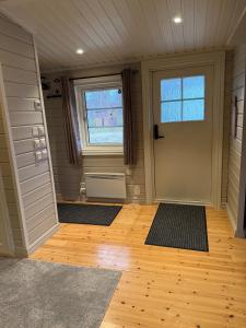 a room with a door and a window and mats at Koselig hytte in Skillemo