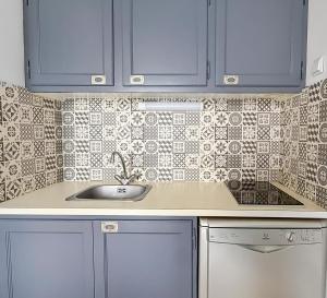 a kitchen with blue cabinets and a sink at Petit cocon, parking et piscine à Marseillan in Marseillan +27 photos