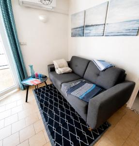 a couch in a living room with a table at Petit cocon, parking et piscine à Marseillan in Marseillan