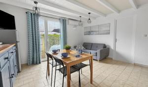 a kitchen and living room with a table and chairs at Petit cocon, parking et piscine à Marseillan in Marseillan
