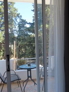 a view of a patio with a table and chairs at Forest Calm Faliraki in Faliraki