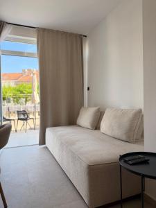 a living room with a couch and a table at Apartments M&E in Mokošica +19 photos