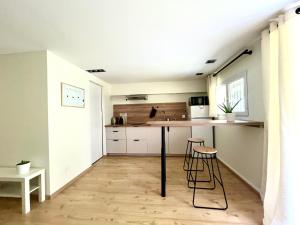 a kitchen with a counter and stools in a room at Le Studio nature de La Pra in Herbeys