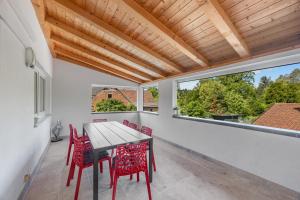 a dining room with red chairs and a wooden table at Gästehaus Parkblick in Rust