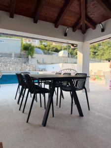 a black table and chairs on a patio at Apartments M&E in Mokošica