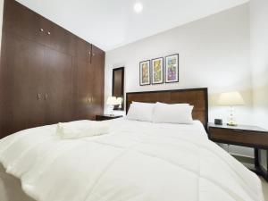 a large white bed in a bedroom with a desk at Amazing apartment near US Consulate in Guayaquil +18 photos