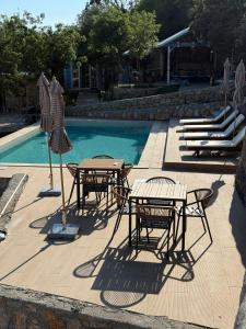 a group of tables and chairs next to a swimming pool at Tramontana Glamping in Bar