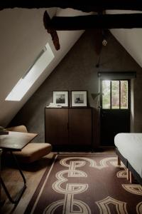 a attic room with a bed and a window at La Dime de Giverny - Chambres d'hôtes-Spa-Restaurant in Giverny