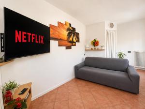 a living room with a couch and a television on a wall at Casa Sophie in Consiglio di Rumo +29 photos