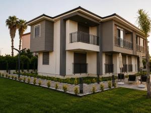 aominium building with a lawn and palm trees at Busera Vida Inn in Ilıcaköy