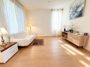 a living room with a white couch and a table at Spacious Private Bedrooms With Full Amenities Near Grocery Stores & Main Highway Routes in Fontana