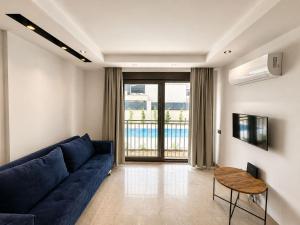 a living room with a blue couch and a table at Busera Vida Inn in Ilıcaköy