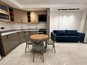a kitchen with a table and chairs and a blue couch at Busera Vida Inn in Ilıcaköy
