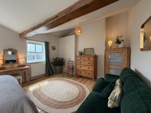 a living room with a green couch and a television at Charming Town House Central Margate in Margate