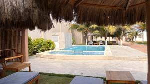 a swimming pool with chairs and umbrellas at Hotel La Mar Playas in Playas