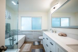 a bathroom with a tub and a sink and a mirror at Private Luxury Getaway | Fire Pit | Near Weddings in Dripping Springs +45 photos