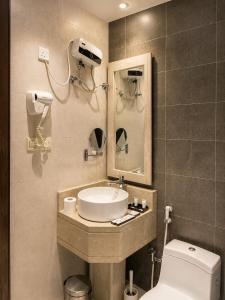 a bathroom with a sink and a toilet and a mirror at شركة نيلوفر بلس للخدمات الفندقيه in Abha