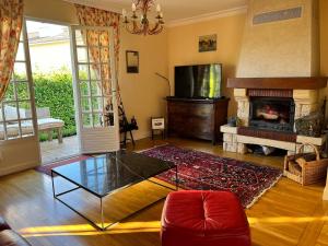 een woonkamer met een glazen salontafel en een open haard bij House with garden in Pérouges