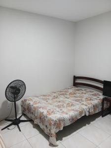 a bedroom with a bed and a fan at Pousada Santa face Rua do Cruzeiro 395 endereço in Juazeiro do Norte