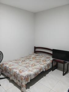 a bed in a room next to a piano at Pousada Santa face Rua do Cruzeiro 395 endereço in Juazeiro do Norte
