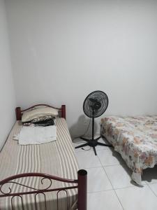 a bedroom with a bed and a fan in a room at Pousada Santa face Rua do Cruzeiro 395 endereço in Juazeiro do Norte