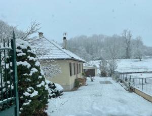 een huis met sneeuw op de grond naast een hek bij House with garden in Pérouges