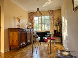 een kamer met een tafel en stoelen en een raam bij House with garden in Pérouges