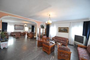 a living room with couches and chairs and a television at Babis Hotel in Karterados