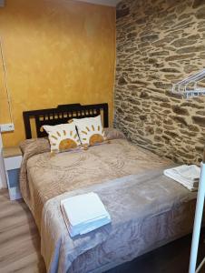 a bedroom with a bed with a stone wall at Casa da Chelo 
