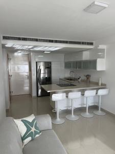 a kitchen with a couch and some bar stools at Apartamento en Pampatar in Pampatar +5 photos