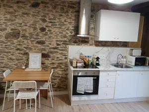 a kitchen with white cabinets and a table with chairs at Casa da Chelo  +8 photos