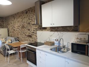 a kitchen with white cabinets and a sink at Casa da Chelo 